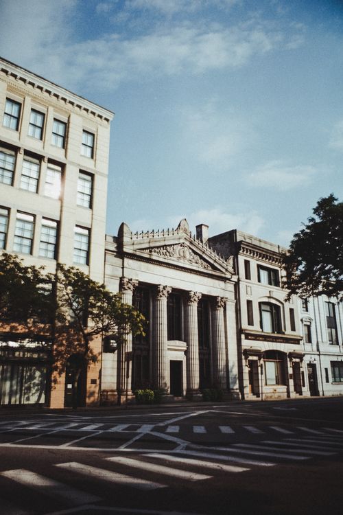Free Neoclassical building facade on a sunny day, showcasing architectural elegance and urban charm. Stock Photo