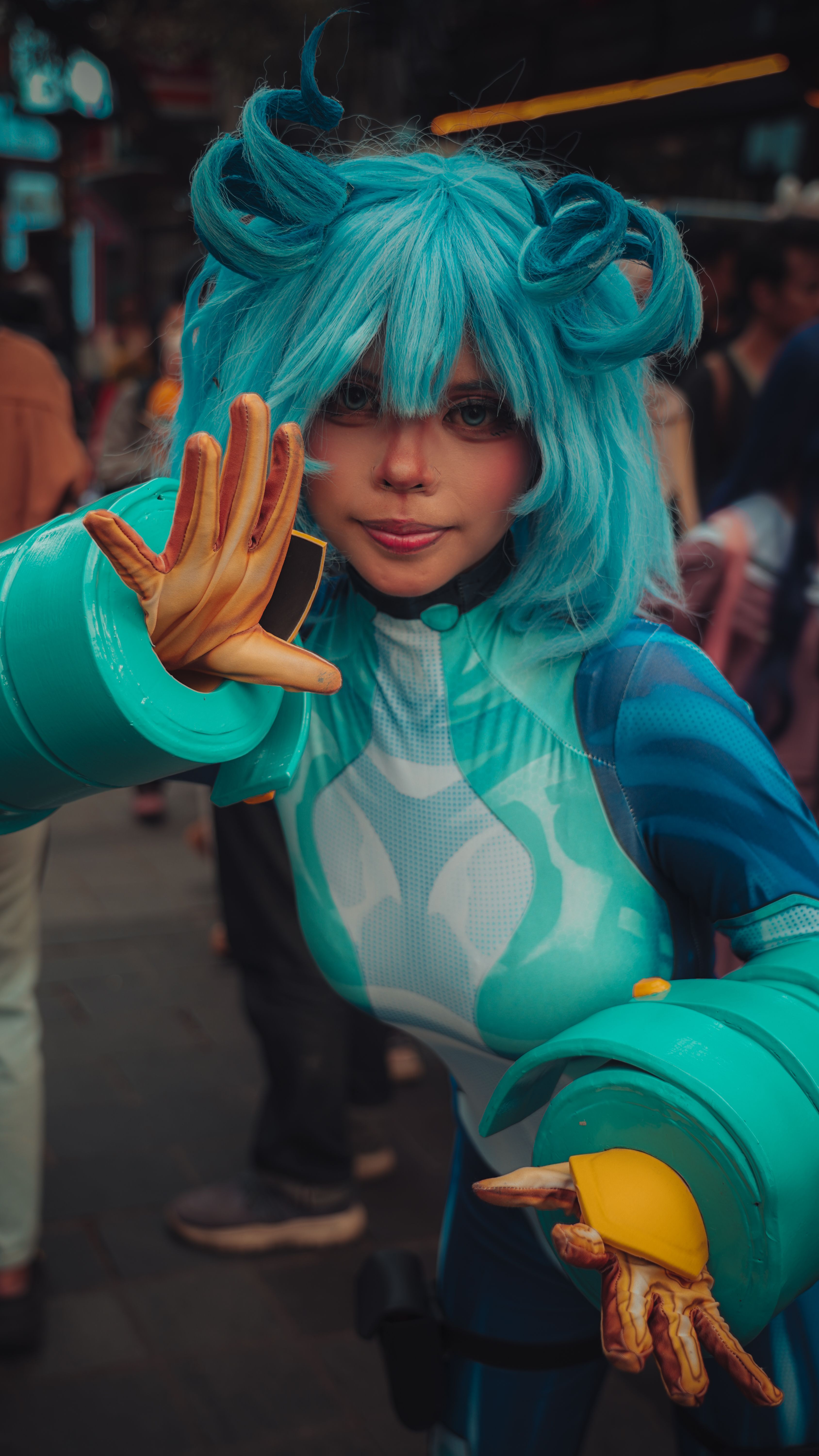 Blue-haired anime character cosplay at outdoor festival during the day.