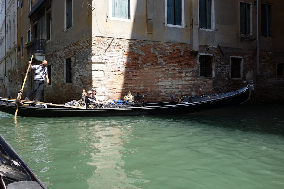 couple enjoying a gondola ride through the canals of Venice - 30 year anniversary trip ideas couple enjoying a gondola ride through the canals of Venice - 30 year anniversary trip ideas