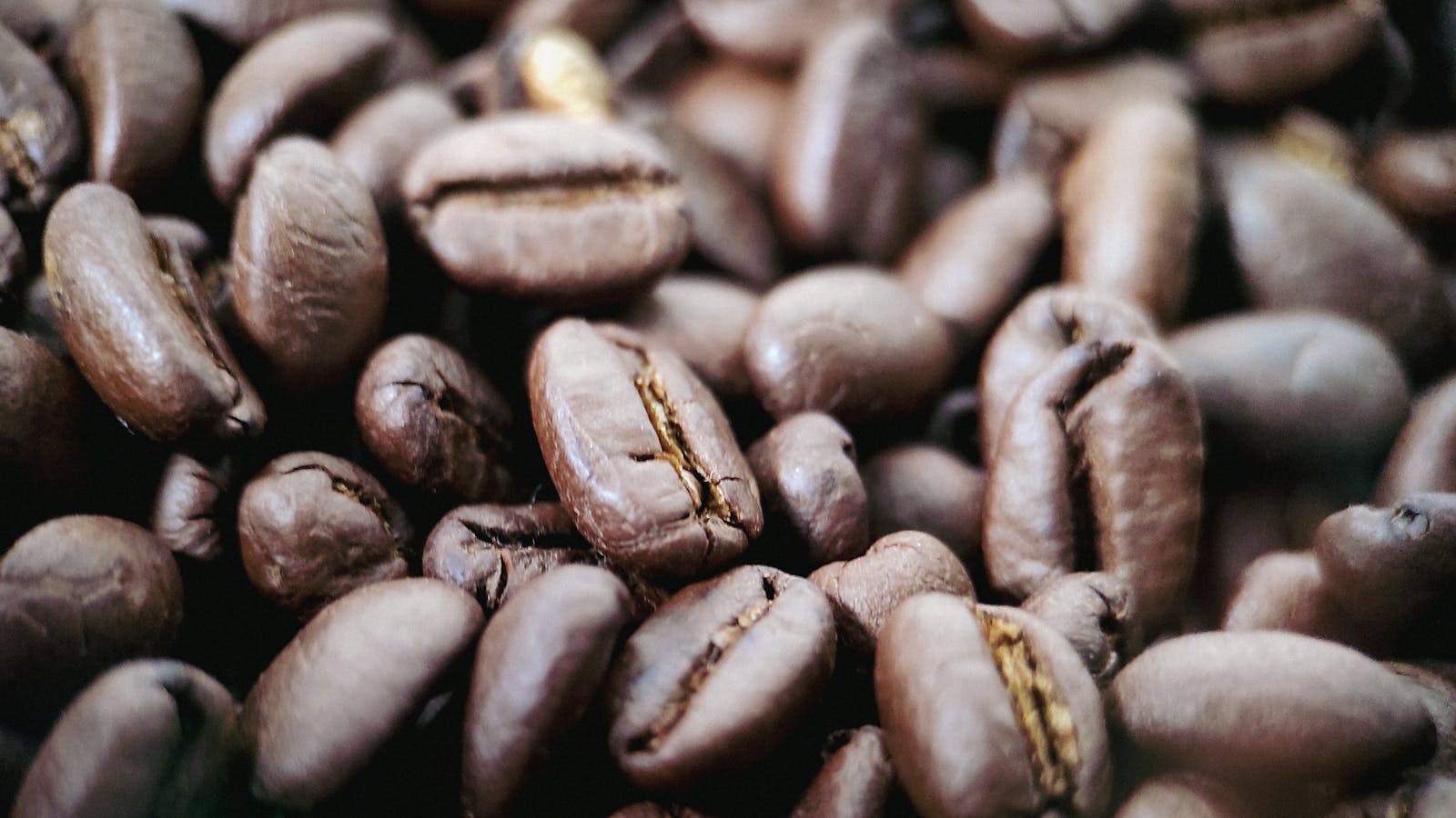 Roasted coffee beans piled together, showing texture and color