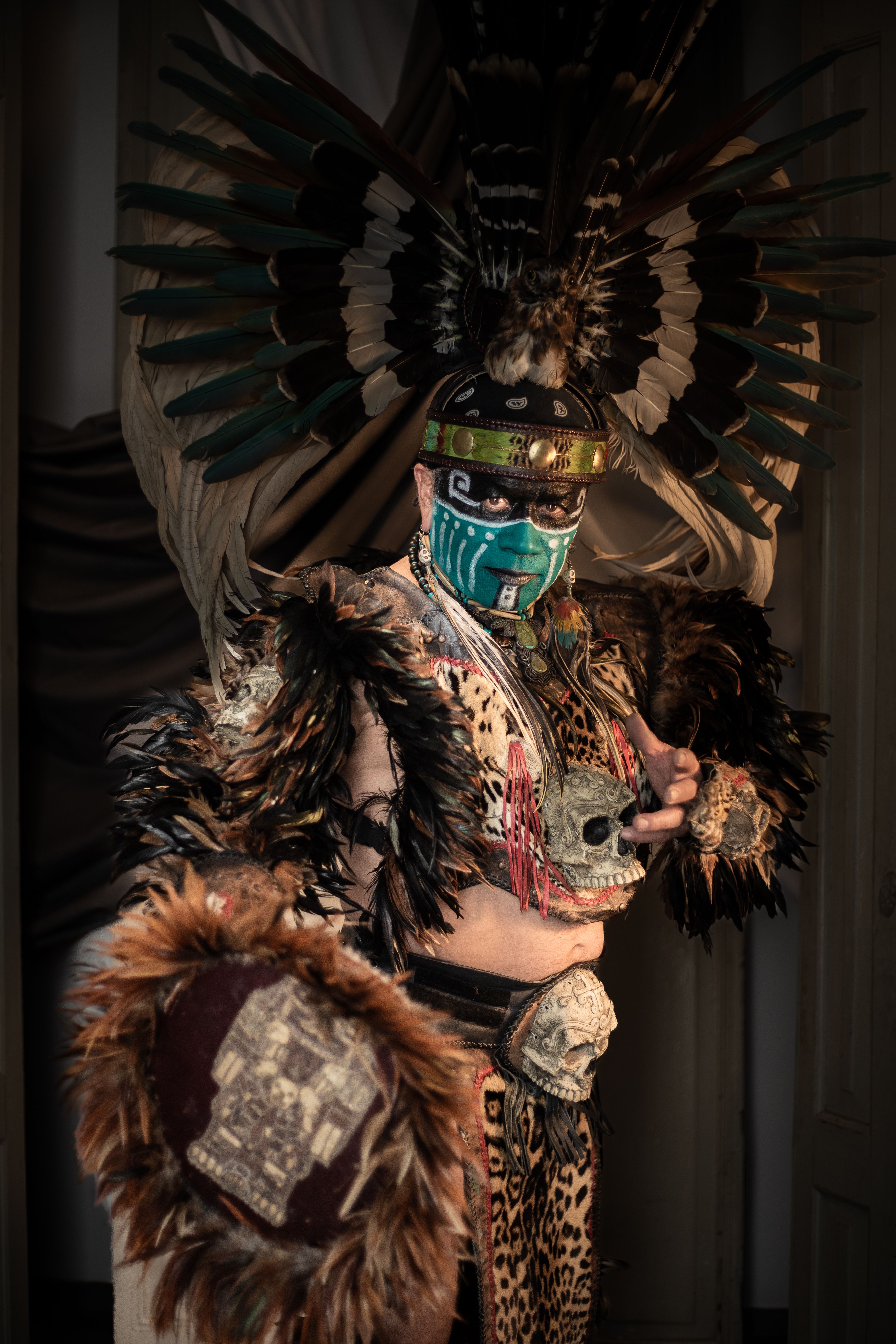A traditional Aztec warrior with intricate feathers and mask, evoking ancient Mexican culture.
