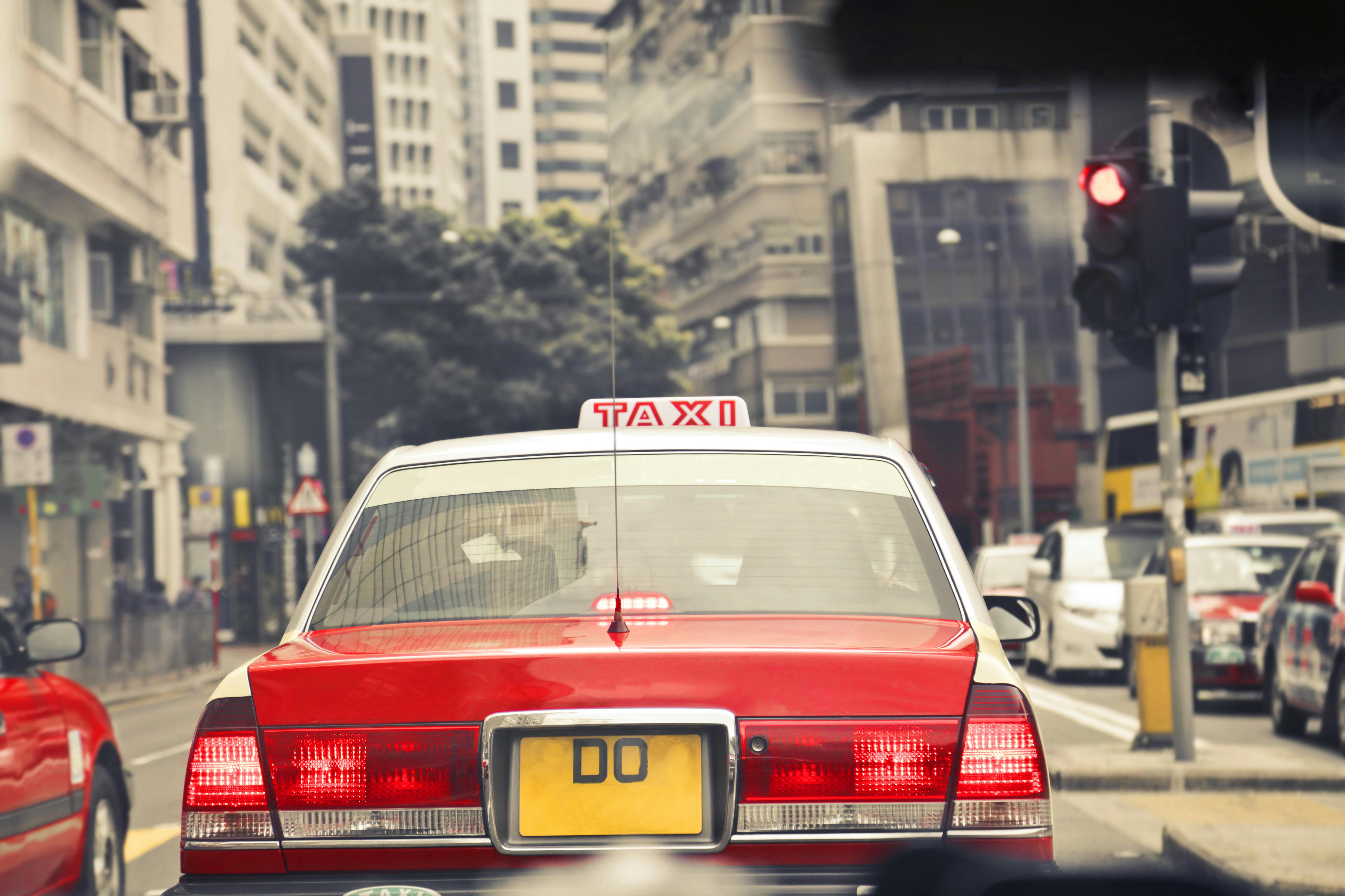 red and white taxi on road