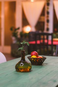 A stylish dining room featuring a green table with a vase and fruit basket, creating a warm ambiance. - Fotografer Sidoarjo
