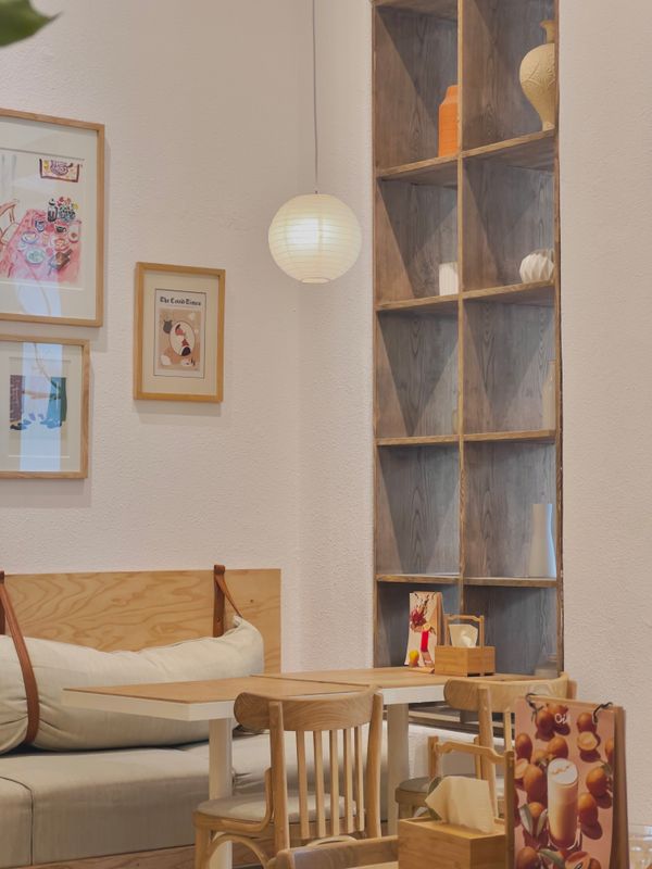 Small café interior with timber seating and framed artwork