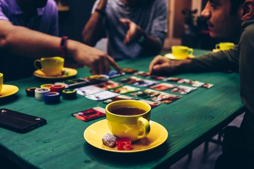 Group playing a board game with tea and snacks