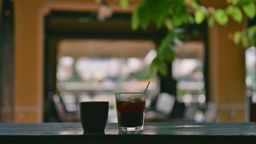 Free Coffee mug and iced drink on a balcony table in a tranquil setting. Stock Photo