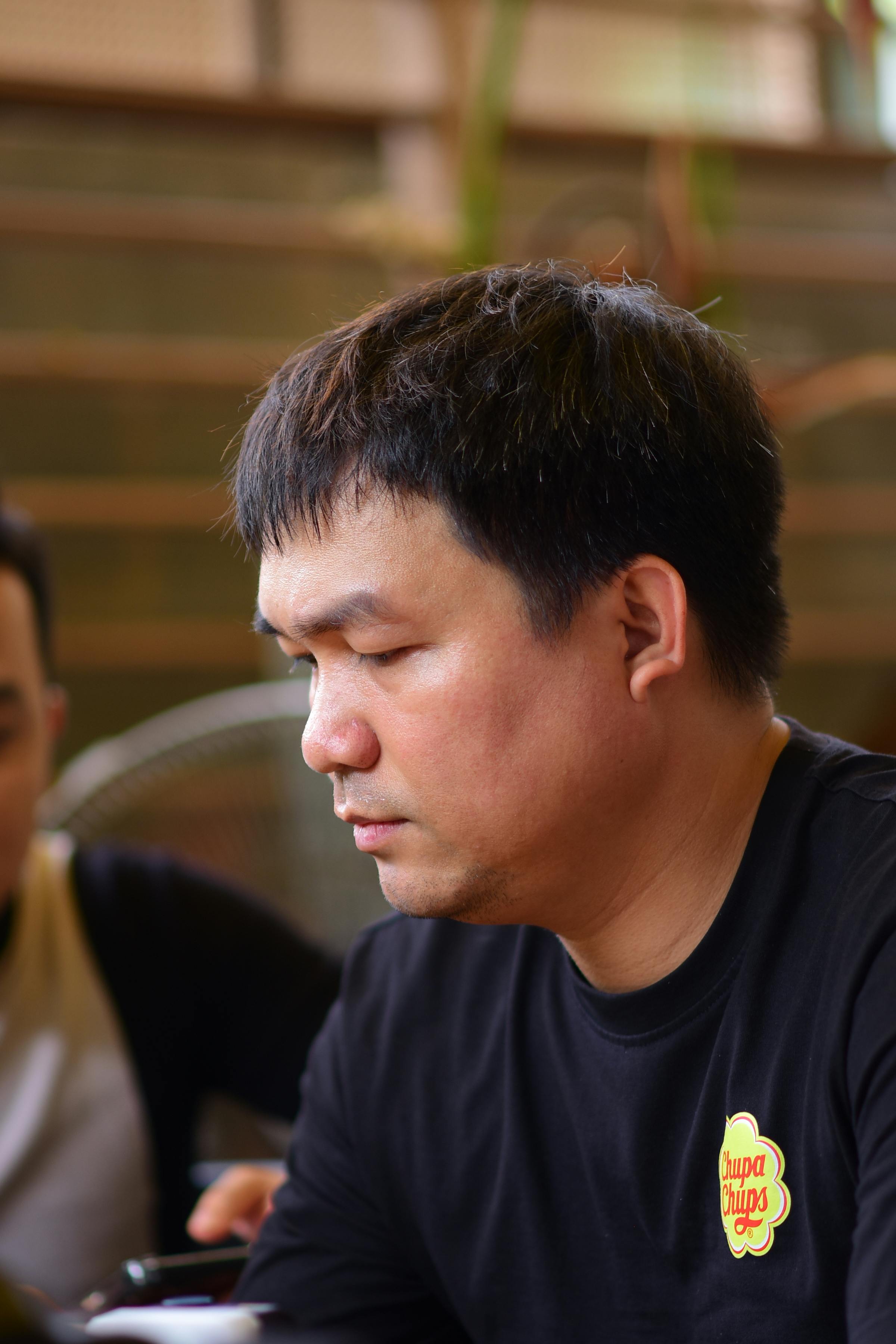 Profile view of a man sitting in a cafe, deep in thought.