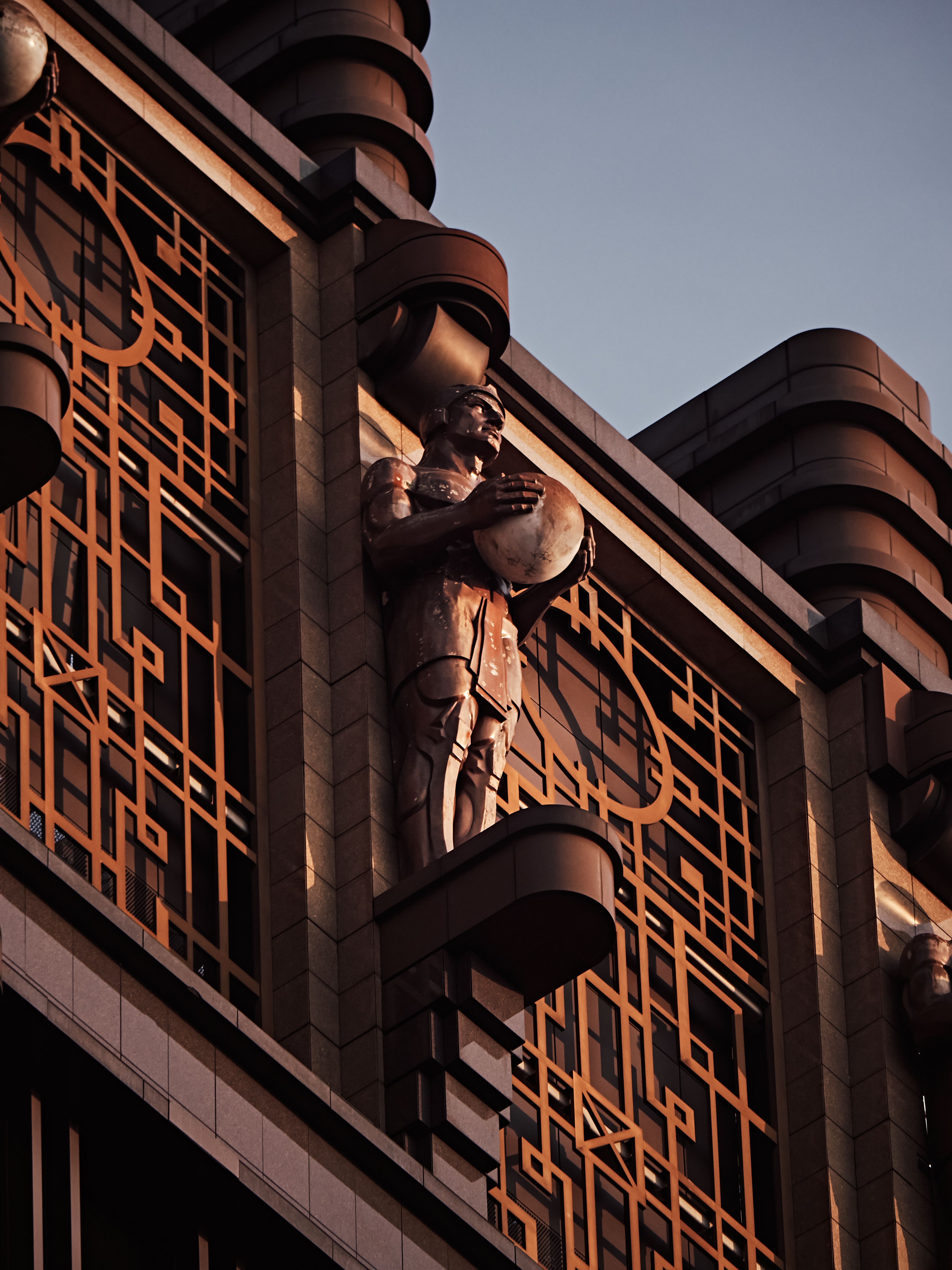 A close-up of an art deco sculpture on a building facade during sunset, evoking a dramatic mood.. pexels, close, deco