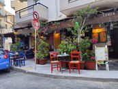 Outdoor café with colorful chairs and lush plants in Heraklion, Greece.