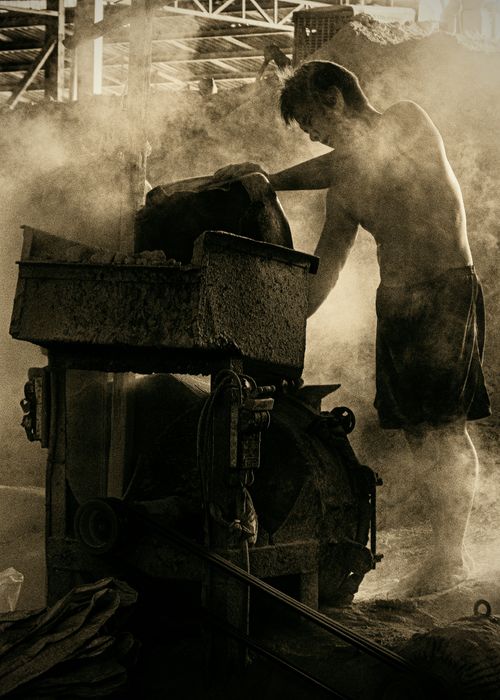 Free A worker operates heavy machinery in a smoky factory setting in Binh Duong, Vietnam. Stock Photo