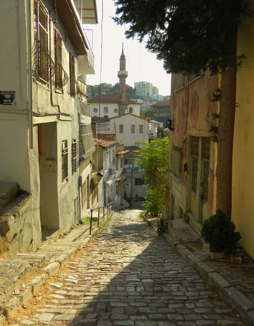 Free Quaint cobblestone street leading to a mosque, capturing the essence of an historic neighborhood. Stock Photo