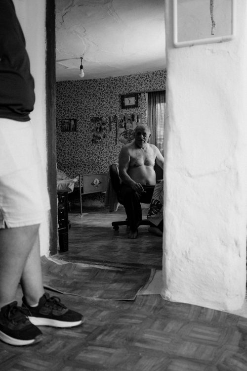 Free Black and white photo capturing a candid moment of a senior adult in a Bulgarian home interior. Stock Photo