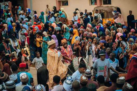 Lively street festival with diverse crowd in colorful traditional attire, embracing culture.