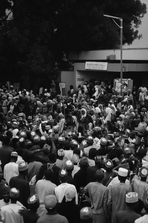 Free A large group of people gathered outdoors in a city setting, captured in monochrome. Stock Photo