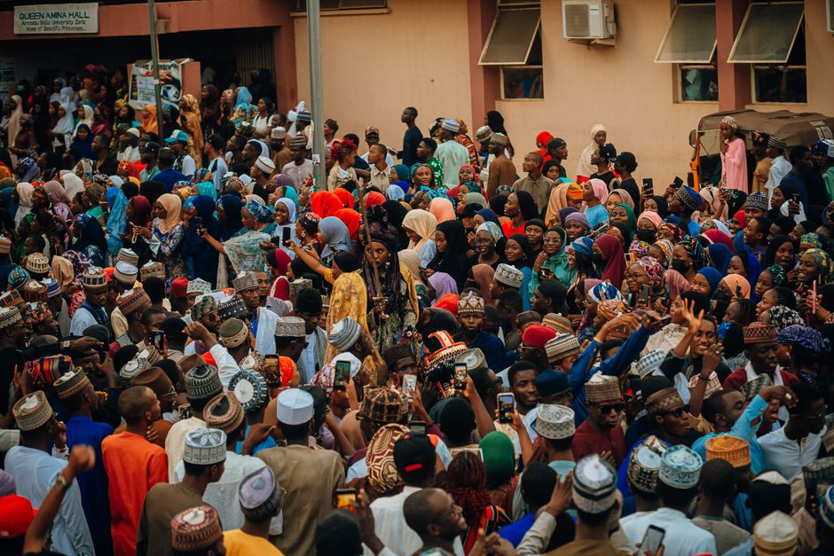 A lively crowd of diverse people celebrating at a cultural festival outdoors.