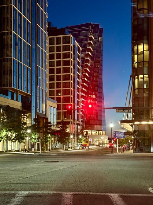 Free City evening scene featuring modern architecture with traffic light, perfect for urban-themed visuals. Stock Photo