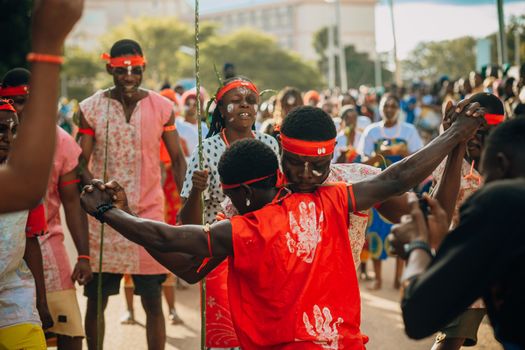 A lively cultural festival with people dancing in traditional attire outdoors.