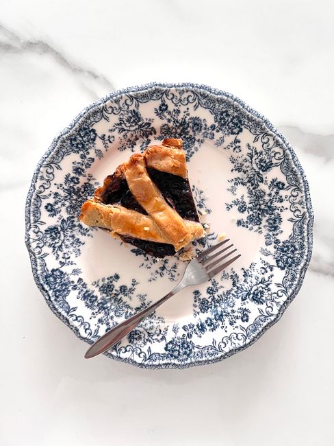 A sliced no-bake icebox pie with a purple-flecked Oreo crust, creamy filling swirled with dark blueberry pie filling, and whole Blueberry Pie Oreo cookies on top.