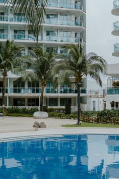 Modern resort with palm trees by the pool, perfect for a tropical vacation.