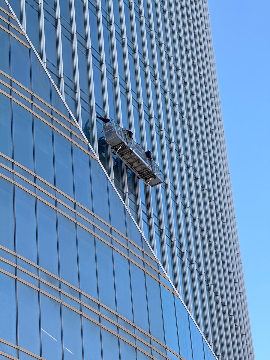 Professional window cleaners working on a modern glass building