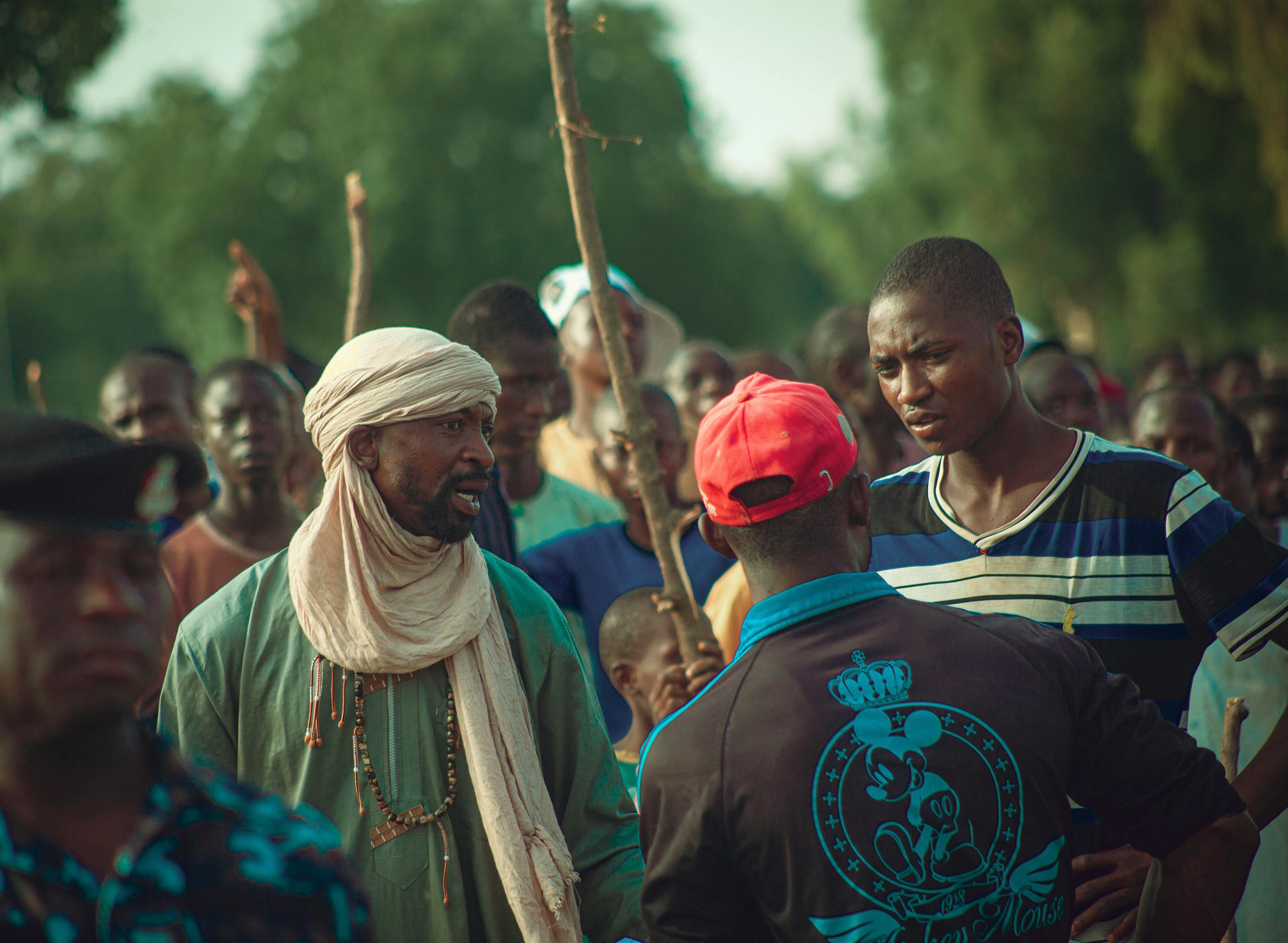 Social Gathering With Diverse People Interacting, Some Engaged In Conversation While Others Observe Quietly