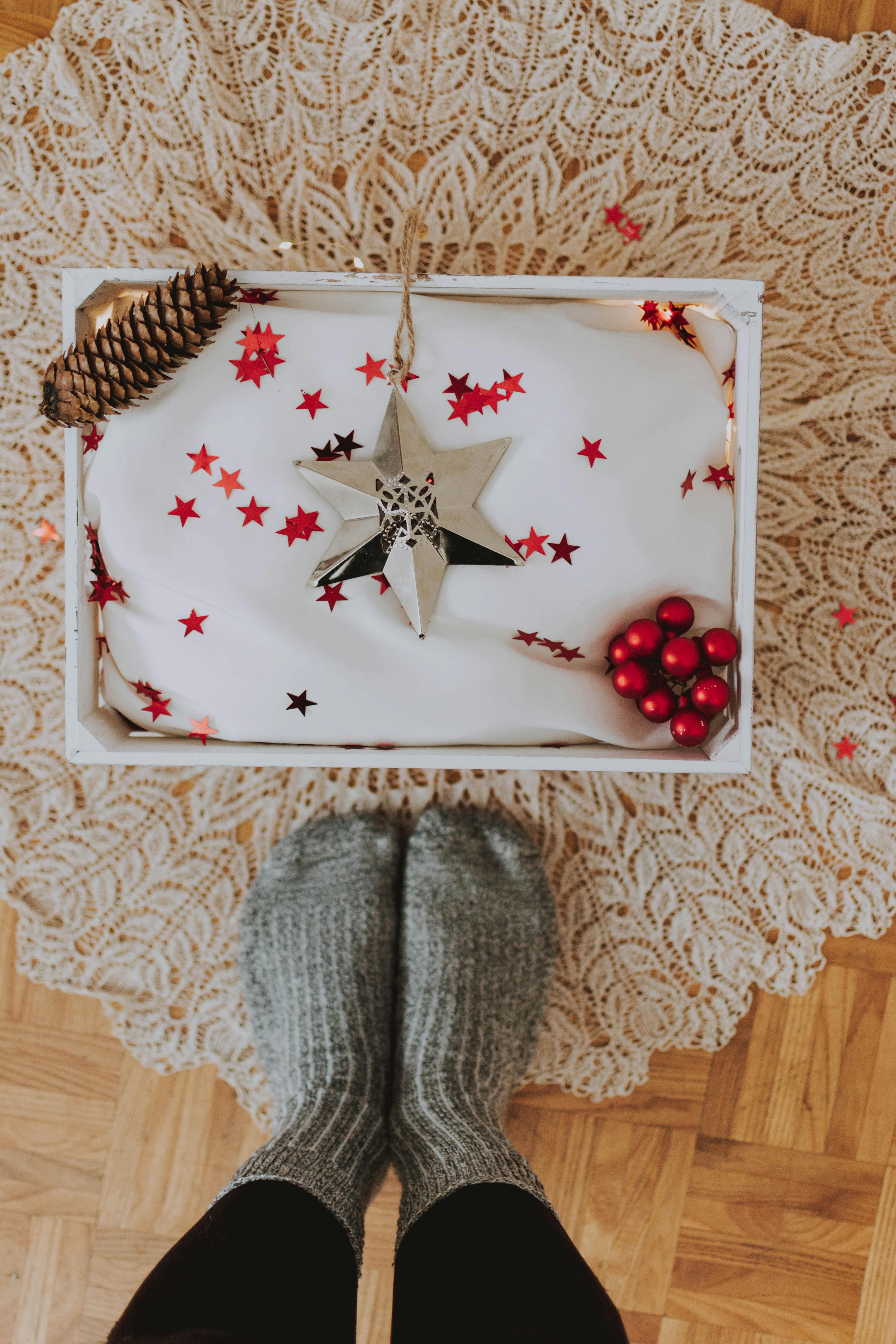 木地板上装饰着圣诞礼品盒，配有舒适的羊毛袜子