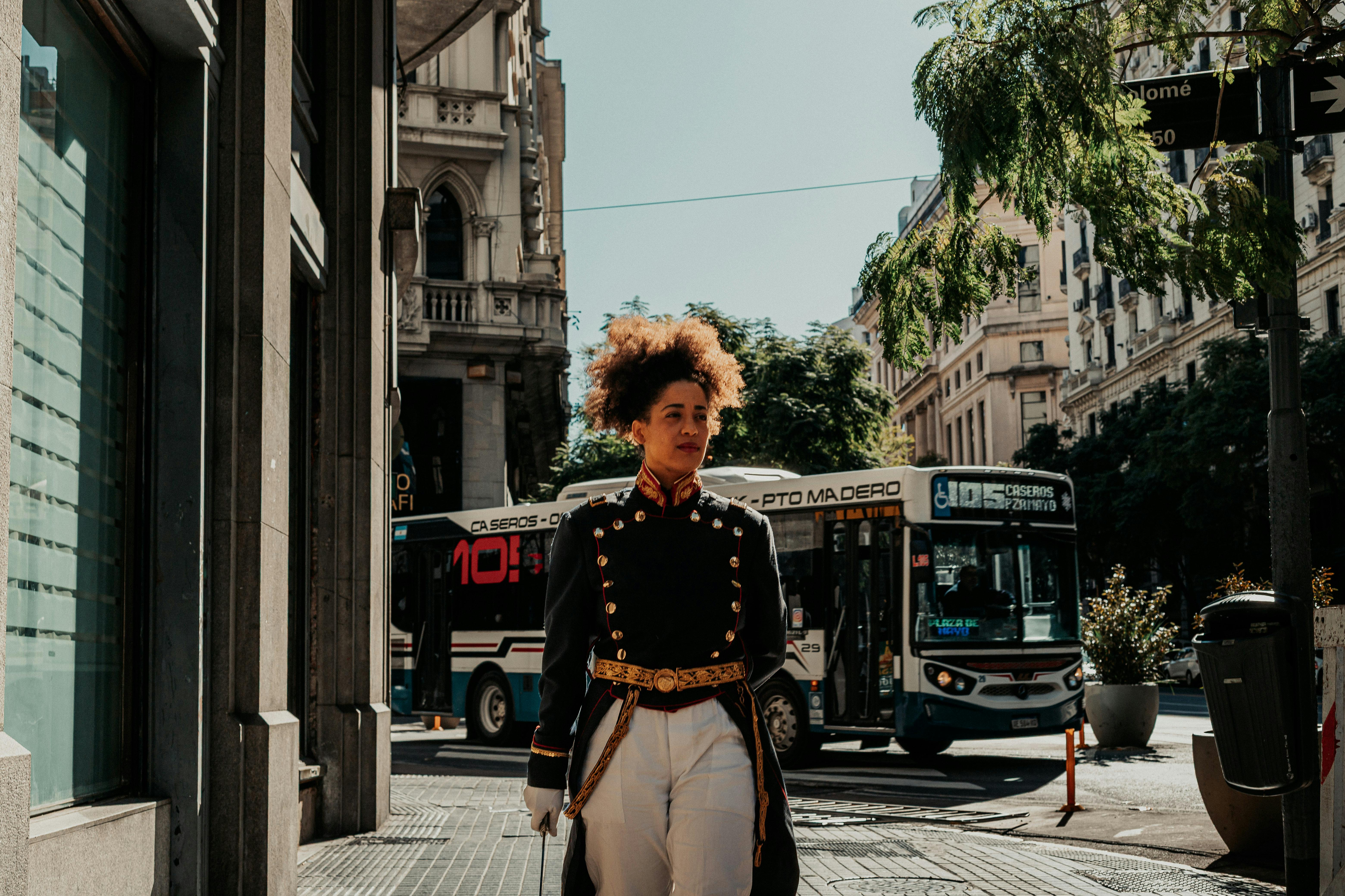 A person in traditional attire walks along a bustling street in Buenos Aires, Argentina.