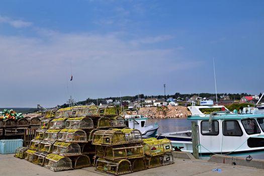 Scenic view of lobster traps and boats at a harbor in Nova Scotia, Canada on a sunny day.