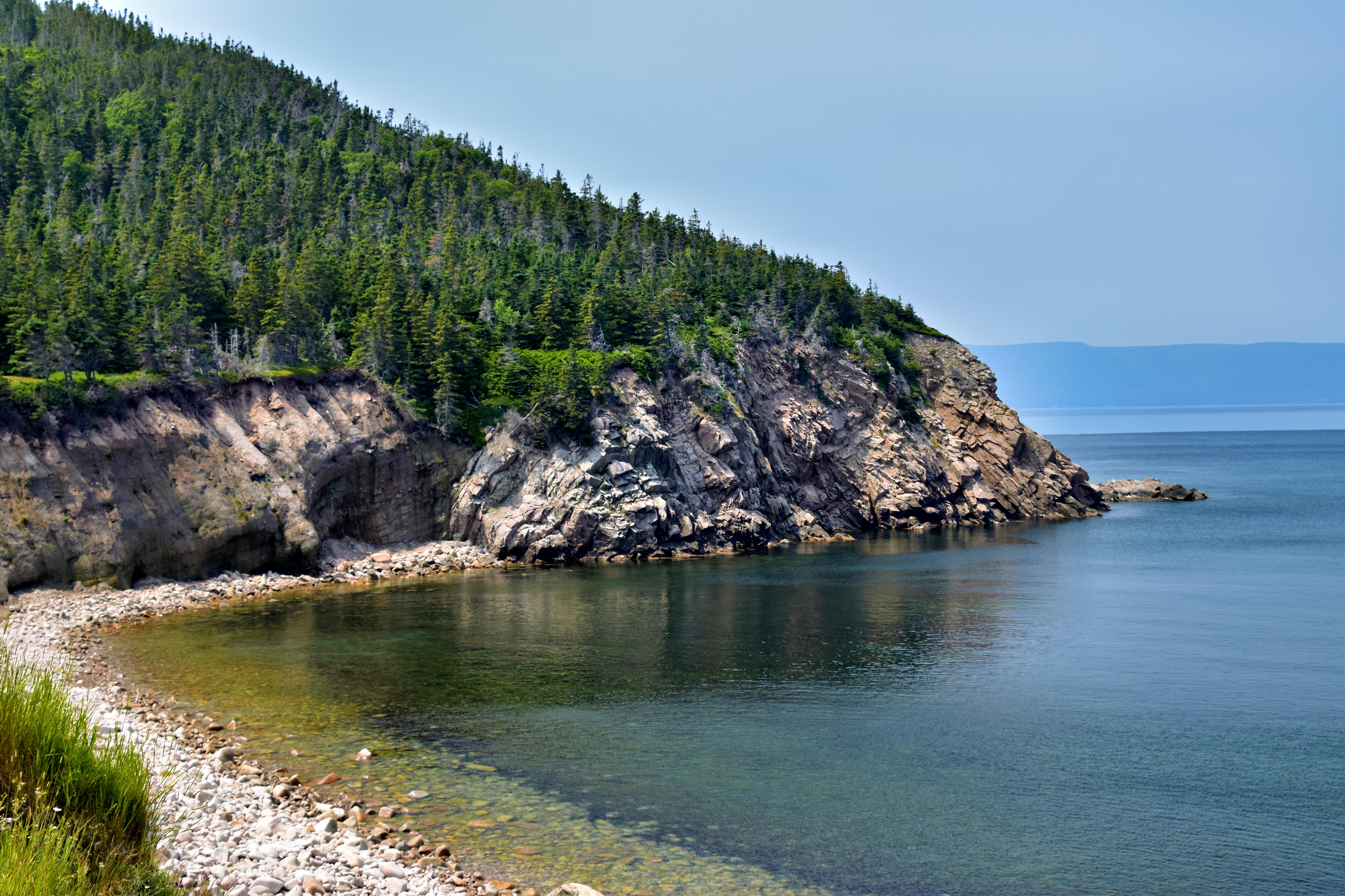 Breathtaking view of rocky cliffs and serene ocean in Nova Scotia, perfect for nature enthusiasts.