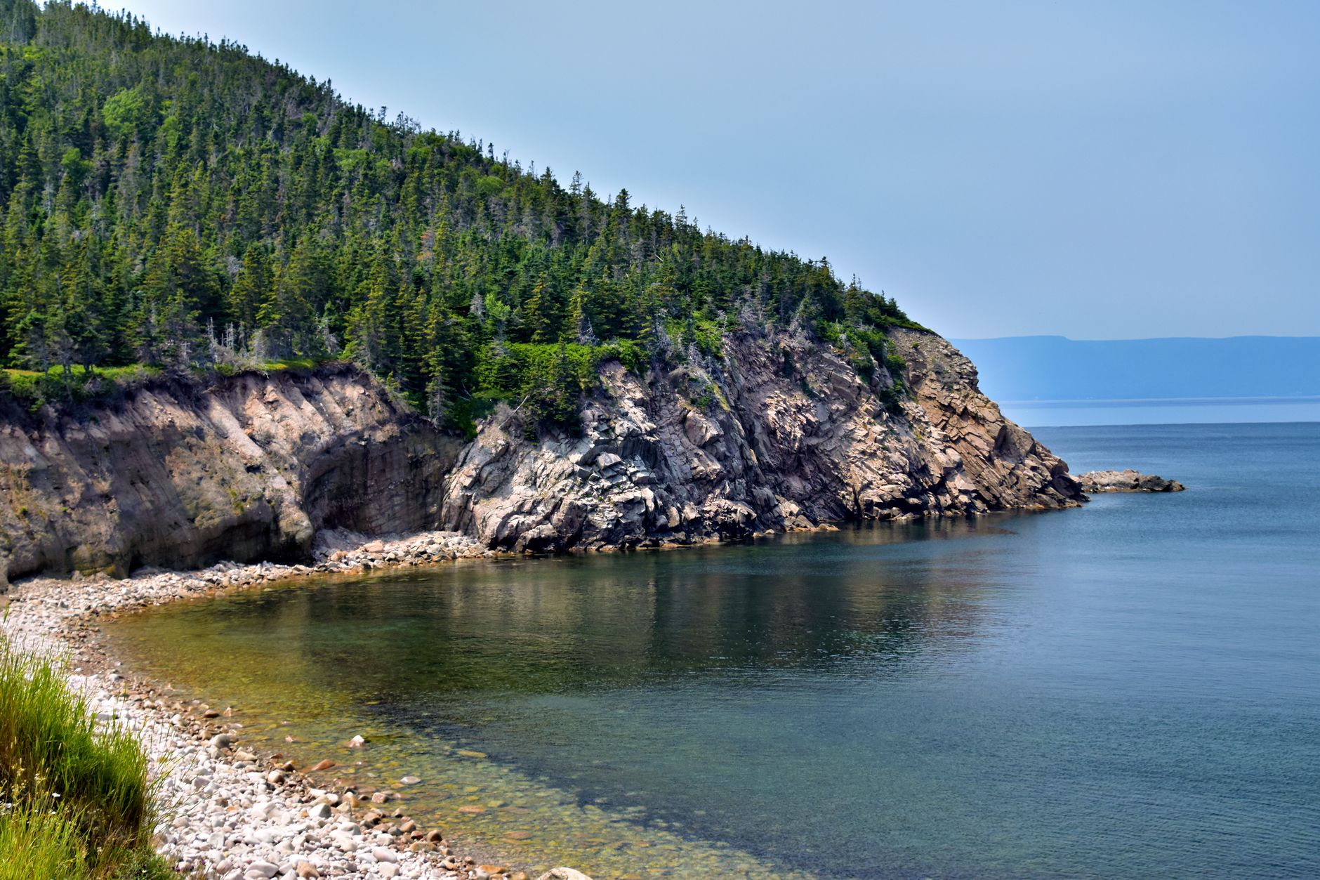 Breathtaking view of rocky cliffs and serene ocean in Nova Scotia, perfect for nature enthusiasts.