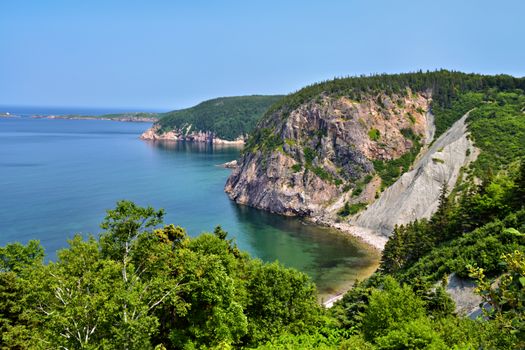 Breathtaking view of Cape Breton's coastline in Nova Scotia, showcasing lush greenery and ocean cliffs.