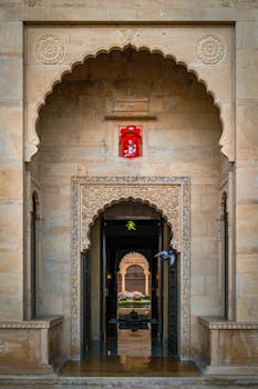 Explore the majestic entrance of Suryagarh Palace, showcasing ornate architecture in Jaisalmer, Rajasthan.