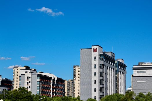 Contemporary cityscape featuring urban buildings against a vibrant blue sky.
