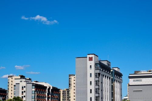 Free Cityscape featuring modern buildings against a vivid blue sky. Ideal for urban-themed projects. Stock Photo