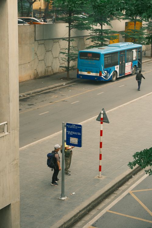 Free People waiting at a bus stop in Hà Nội, with city bus and street view. Stock Photo