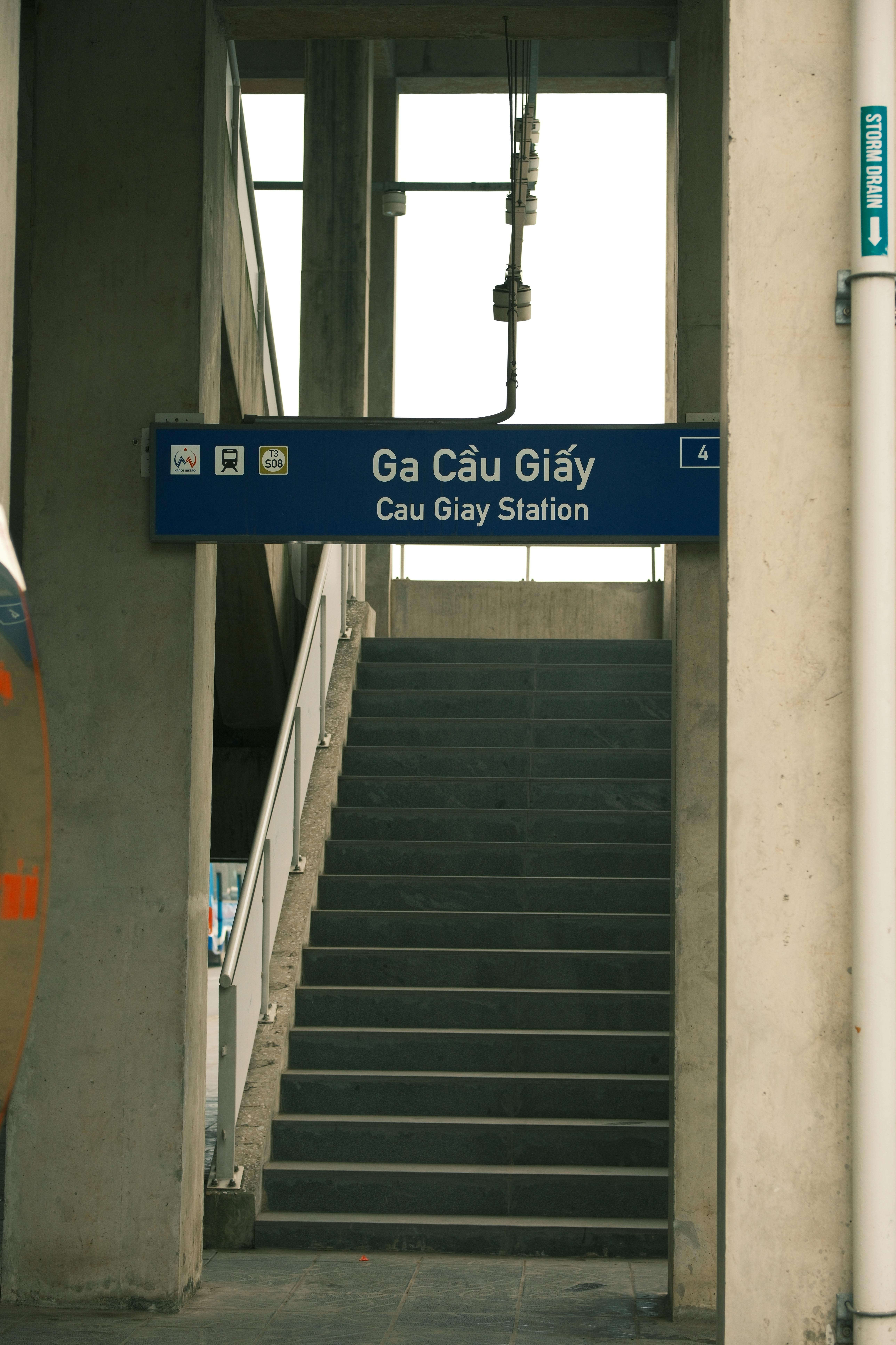 Staircase leading to Cau Giay Station in Hà Nội, Vietnam, featuring bilingual signage.