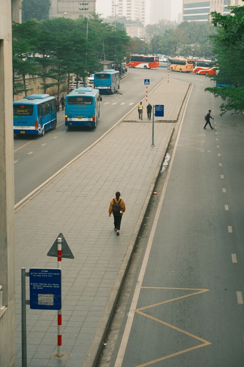 Free Aerial view of a busy street in Hanoi, Vietnam with buses and pedestrians on a foggy day. Stock Photo
