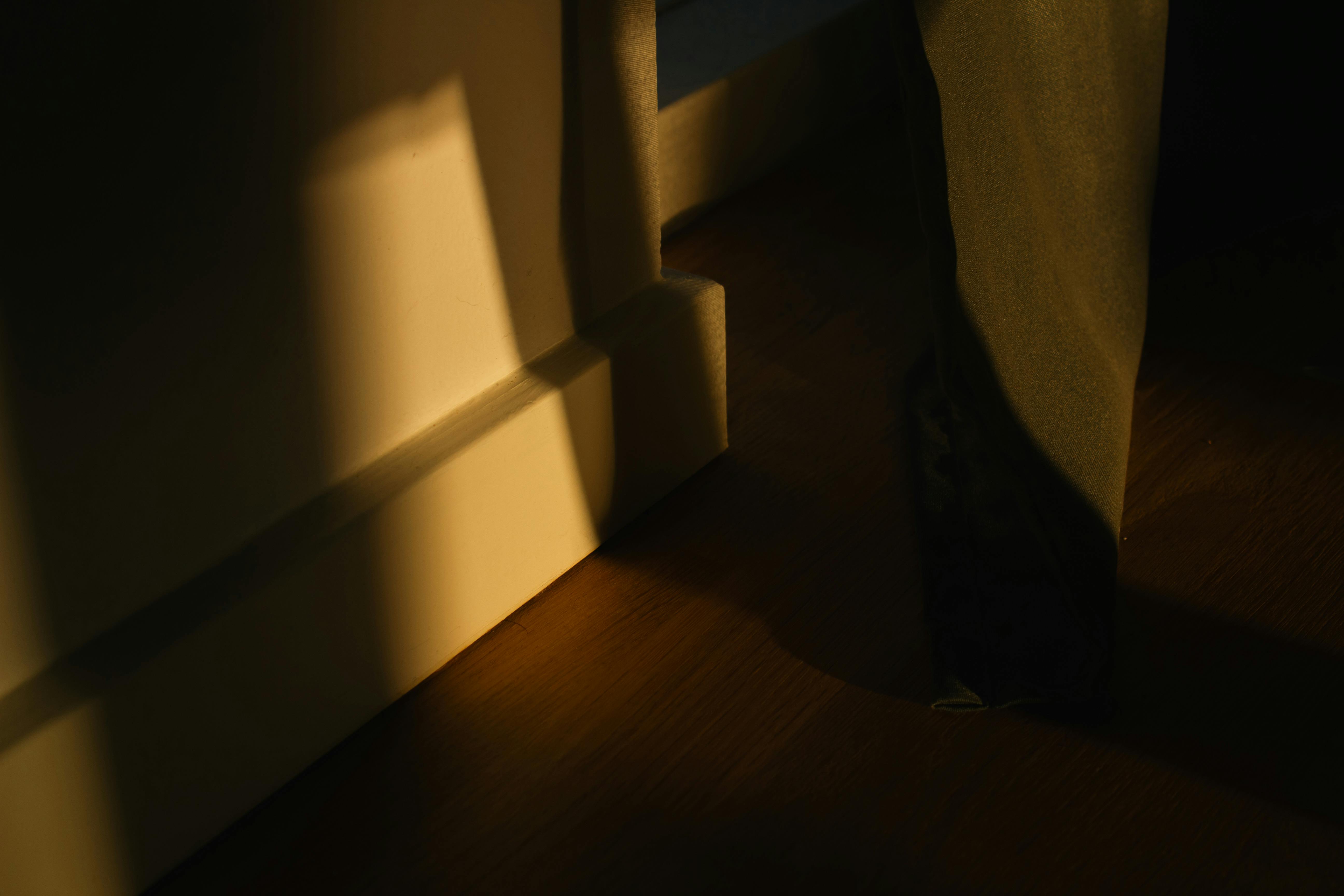 Gratuit Captură artistică a luminii calde a serii care proiectează o umbră în interior, creând o scenă dramatică. Fotografie de stoc