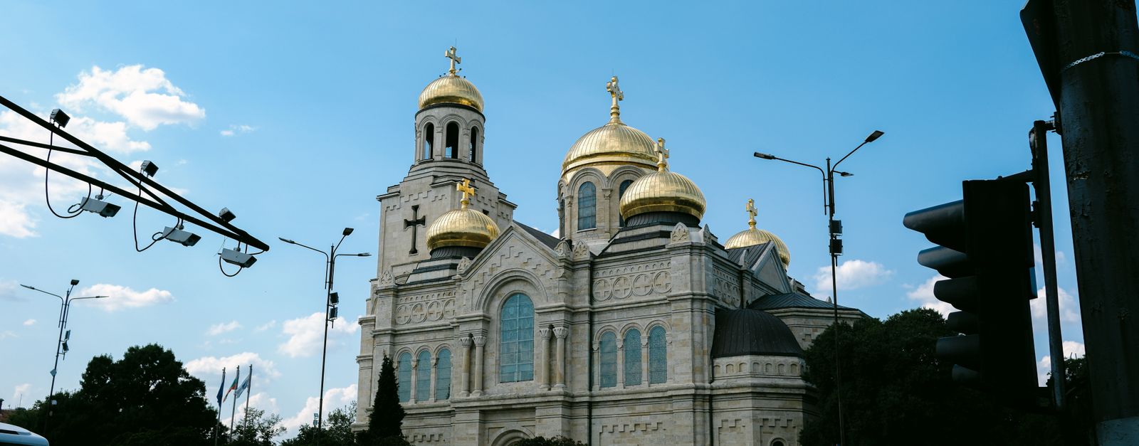 Street view of Varna Cathedral's golden domes in Bulgaria against a clear sky.