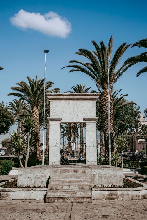 Free Yanahuara Arch surrounded by palm trees under a clear blue sky in Arequipa, Peru. Stock Photo