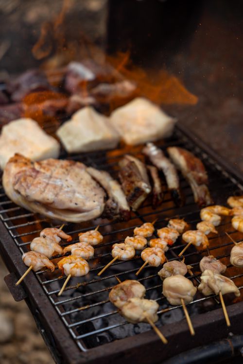 Free A sizzling barbecue grill with skewered shrimp, chicken, and ribs, creating a savory outdoor feast. Stock Photo