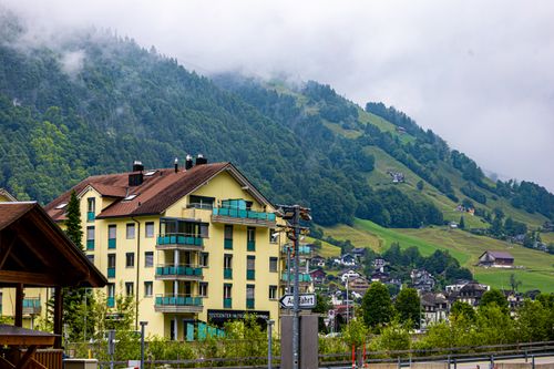 Free Charming mountain town with residential buildings and lush greenery on a cloudy day. Stock Photo