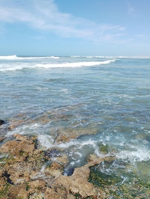 Free Waves crashing on the rocky shore of Casablanca, Morocco under a clear blue sky. Stock Photo