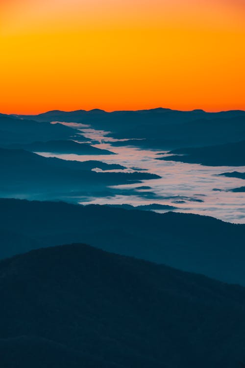 Picturesque mountainous terrain against cloudless sunset sky