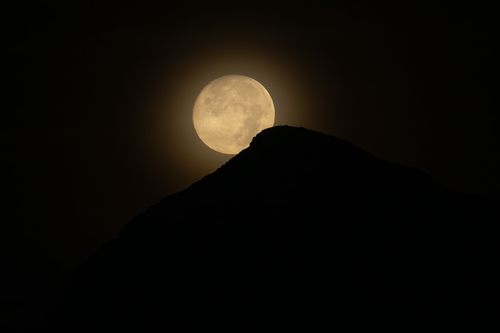 Free Dramatic full moon rising over a silhouetted mountain in Alicante, Spain. Stock Photo