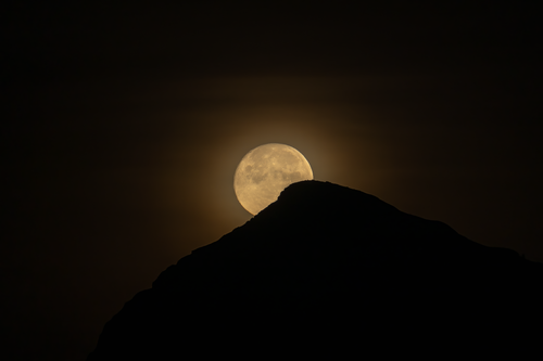 Free Stunning capture of a full moon rising behind a mountain in Alicante, Spain. Stock Photo