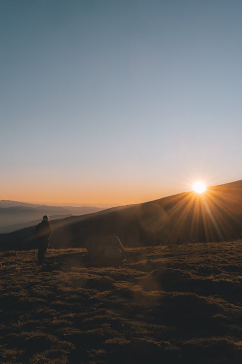 Pejalan Kaki Tak Dikenal Yang Mengagumi Matahari Terbenam Di Atas Lembah Pegunungan