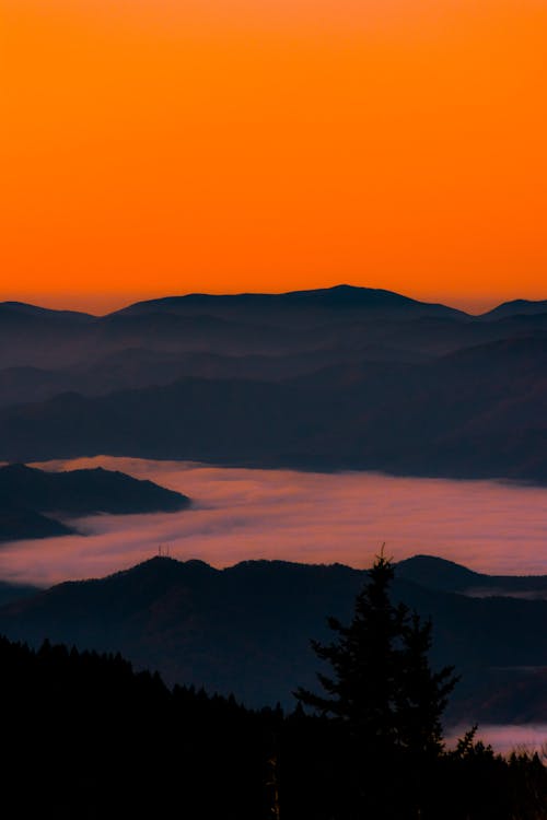 Vivid sunset sky over mountainous terrain with clouds