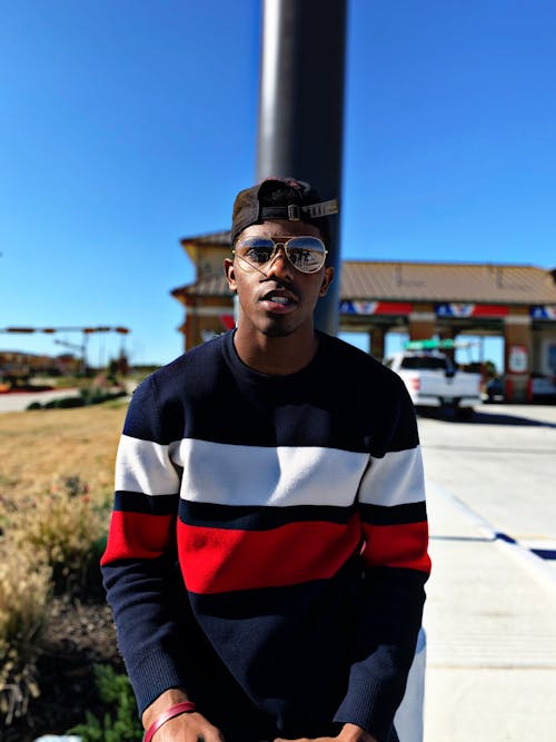 Man Wearing Black, White, and Red Striped Crew-neck Long-sleeved Shirt and Eyeglasses Standing Near Road