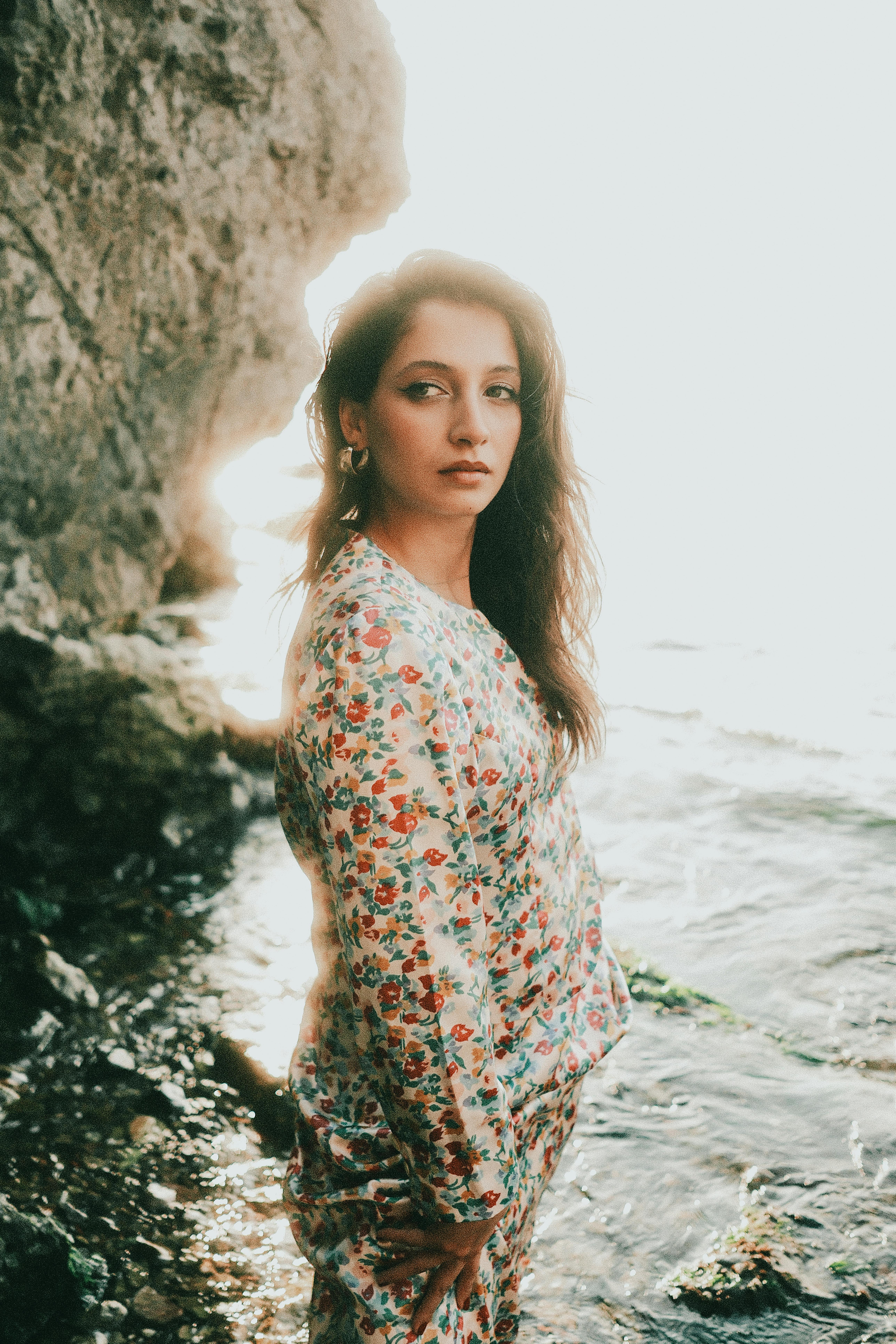 伊斯坦布尔一个阳光明媚的日子里，一位穿着花服的年轻女子在海边摆姿势